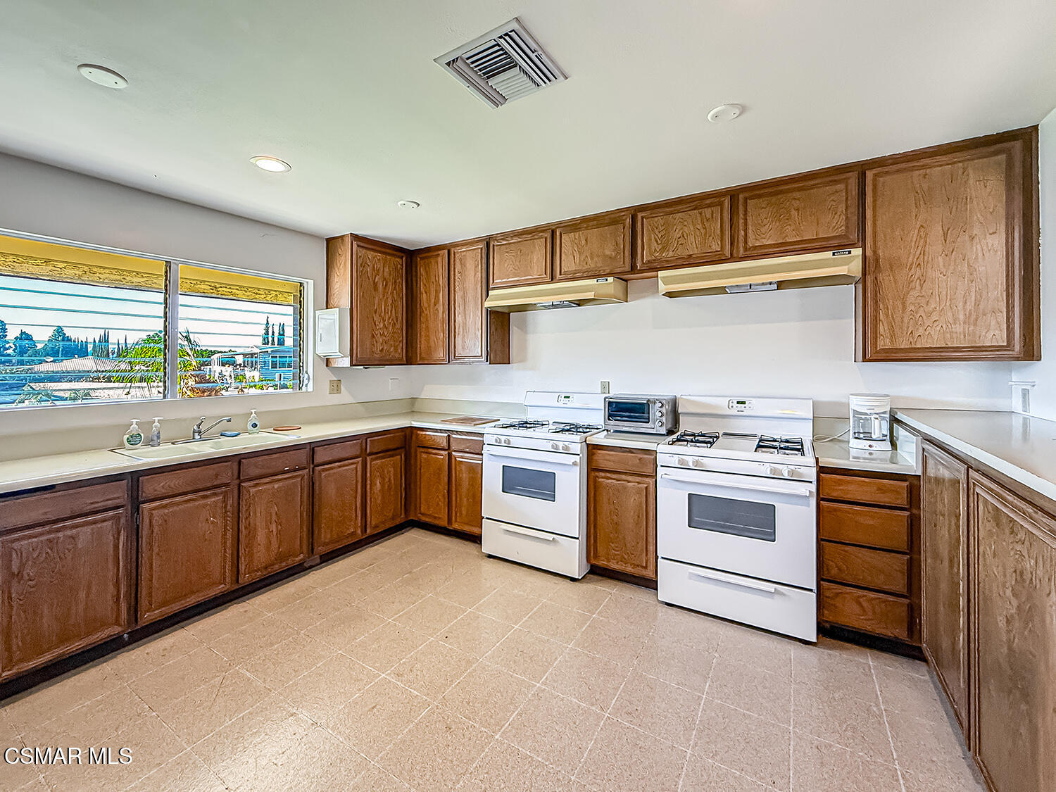 6480 Katherine Street, Unit 109 Simi Valley, CA 93063 - Photo 28 of 29 a kitchen with a stove sink and cabinets
