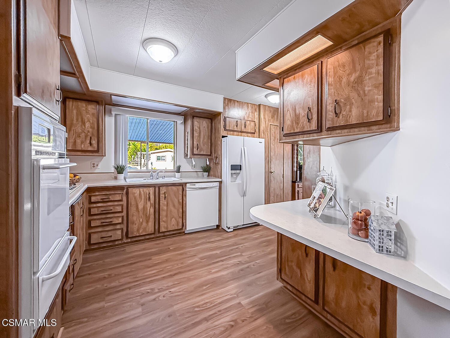 6480 Katherine Street, Unit 109 Simi Valley, CA 93063 - Photo 9 of 29 a kitchen with stainless steel appliances sink refrigerator and window