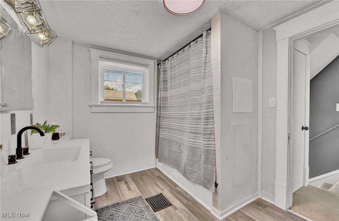 732 Carpenter Street Akron, OH 44310 - Photo 29 of 38 Full bath with vanity, light wood-type flooring, a textured ceiling, and shower / bath combination with curtain