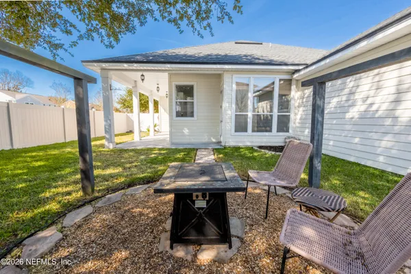 a view of a patio with table chairs and a yard