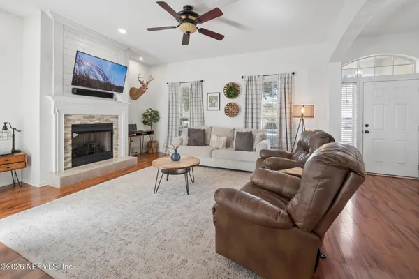 a living room with furniture a fireplace and a flat screen tv