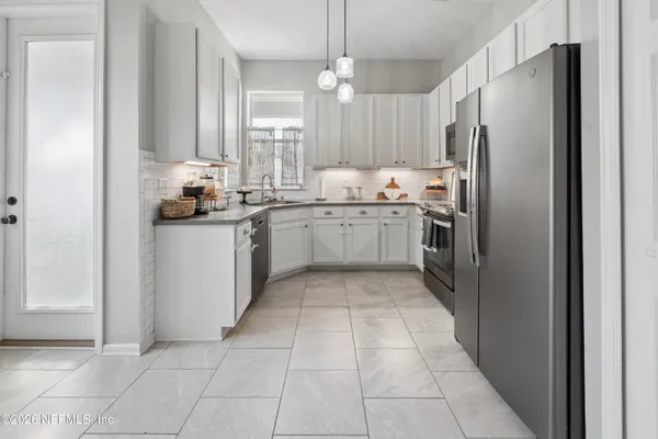 a kitchen with stainless steel appliances granite countertop a refrigerator and a sink