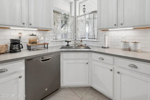 a kitchen with stainless steel appliances granite countertop white cabinets and a sink