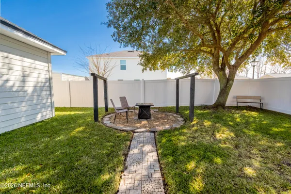 a view of a patio with couches plants and large trees