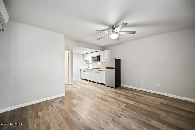 a view of a kitchen with wooden floor and a ceiling fan