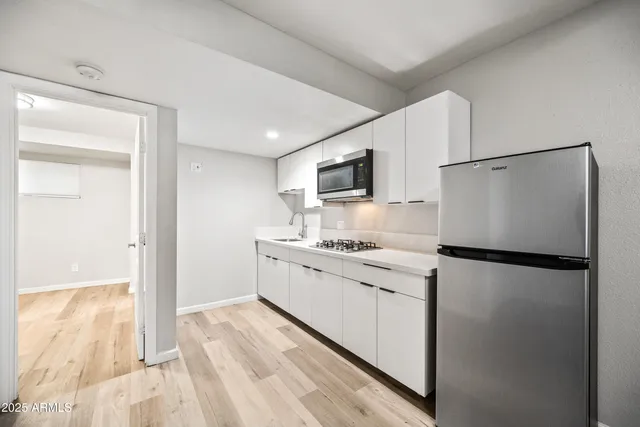 a kitchen with stainless steel appliances a refrigerator sink and microwave