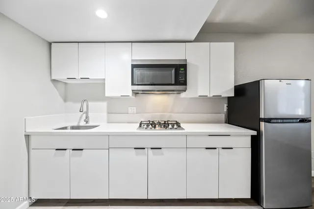 a kitchen with stainless steel appliances a stove refrigerator sink and microwave