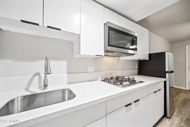 a kitchen with a sink stove and microwave