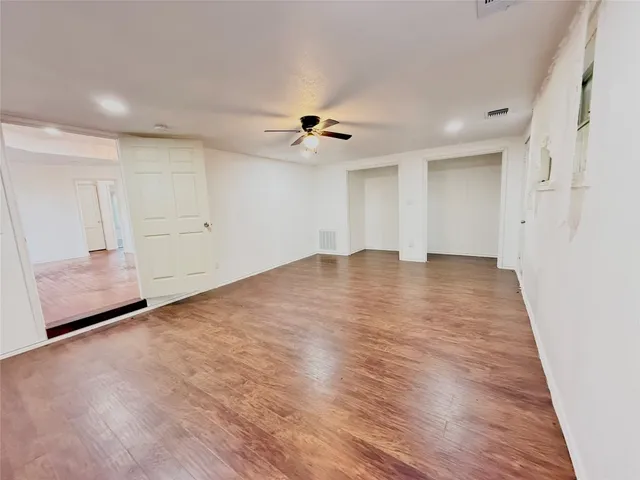 a view of an empty room with wooden floor