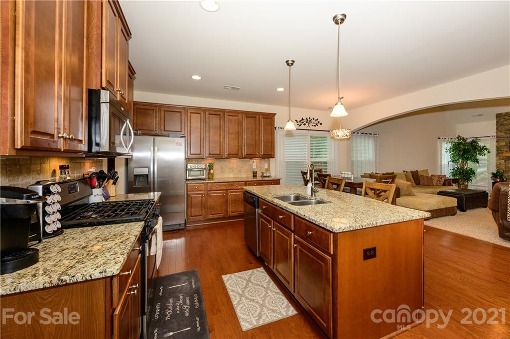 3028 Fallondale Road Waxhaw, NC 28173 - Photo 8 of 29 a kitchen with stainless steel appliances granite countertop a sink a stove and a refrigerator