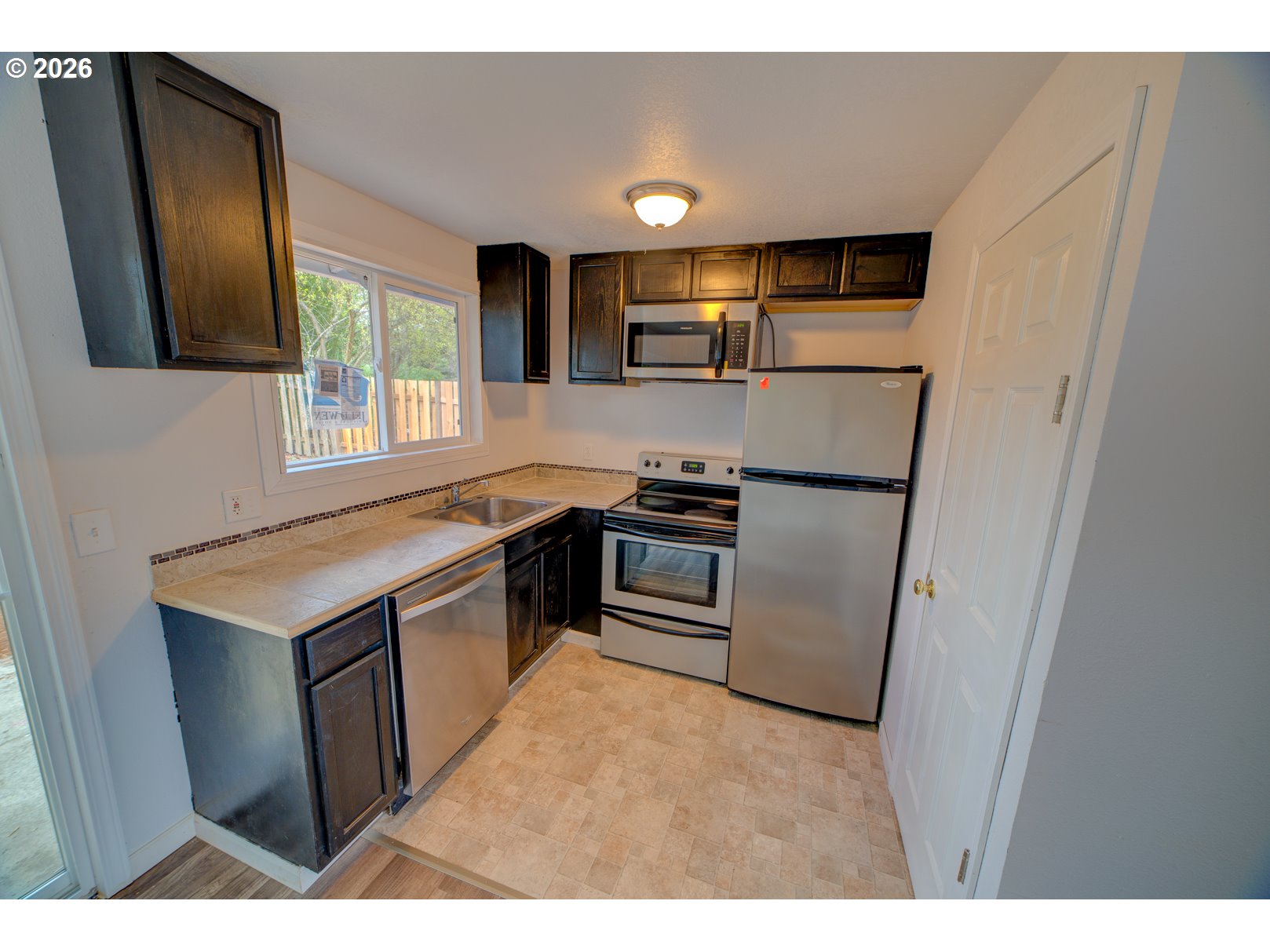 3825 Southwest 198th Avenue Beaverton, OR 97078 - Photo 17 of 23 a kitchen with stainless steel appliances granite countertop a refrigerator a stove a sink and a refrigerator with wooden floor