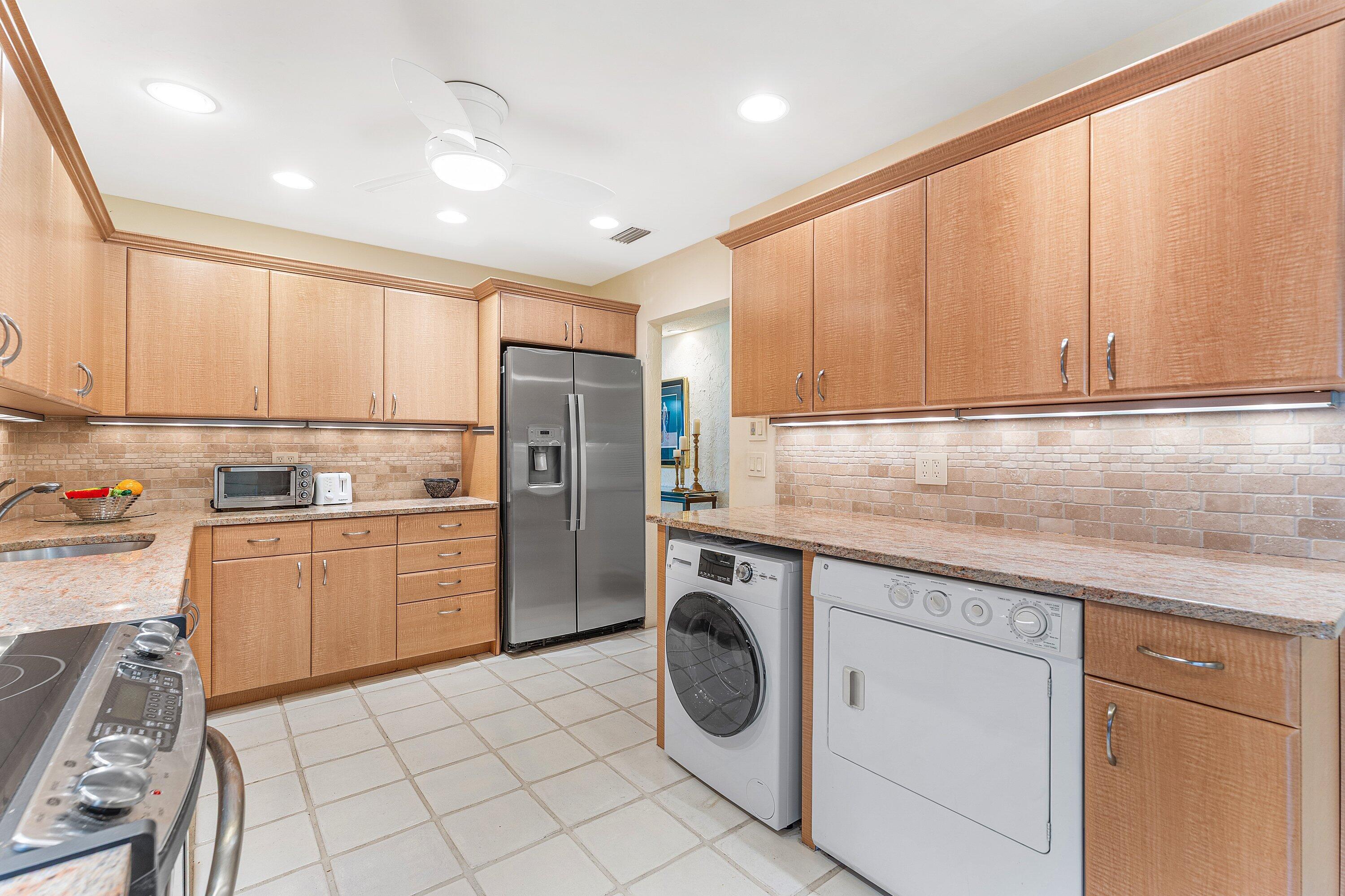 5 Eastgate Drive, Unit A Boynton Beach, FL 33436 - Photo 11 of 49 a kitchen with a refrigerator sink and cabinets