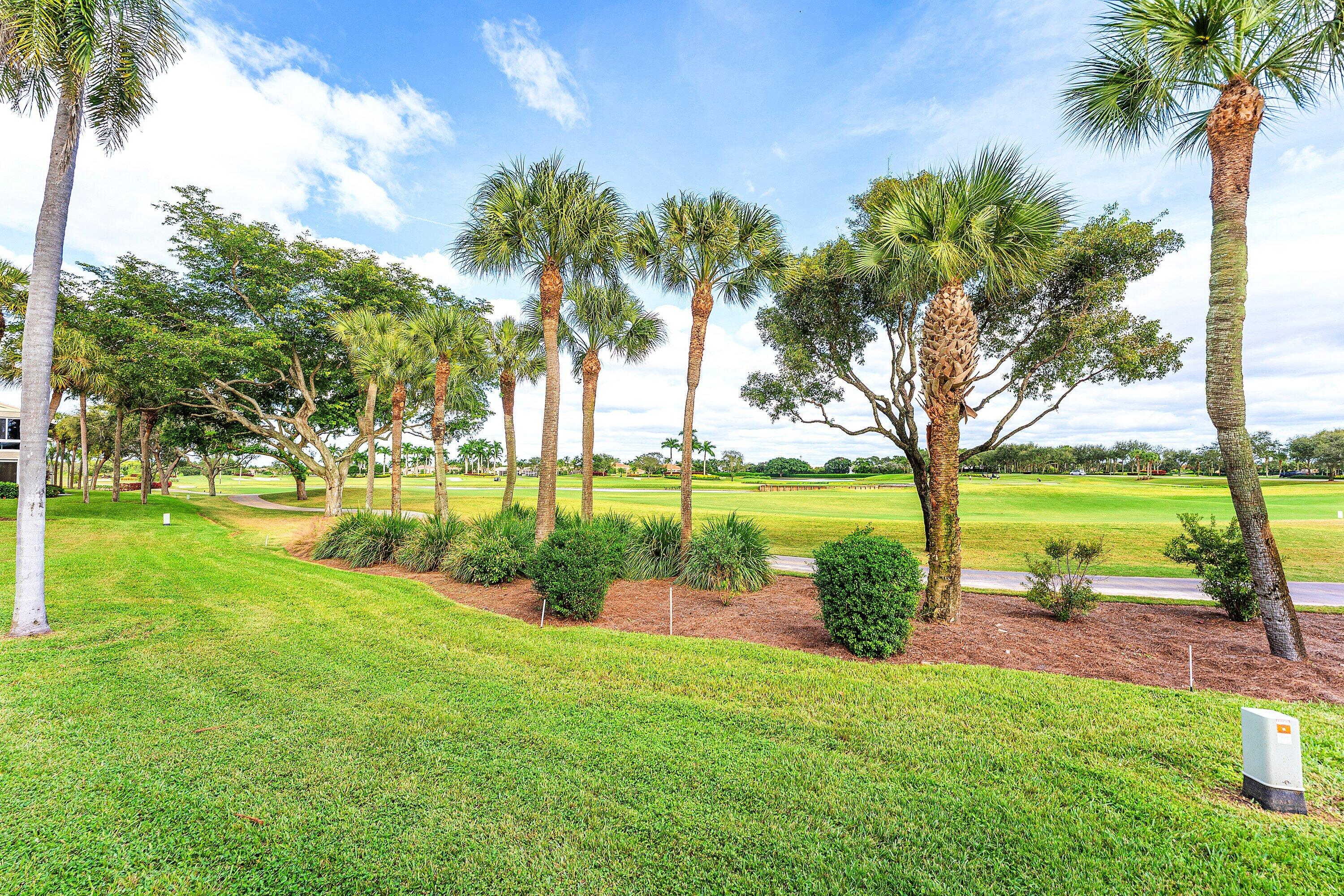 5 Eastgate Drive, Unit A Boynton Beach, FL 33436 - Photo 30 of 49 a view of a lake with a yard and palm trees