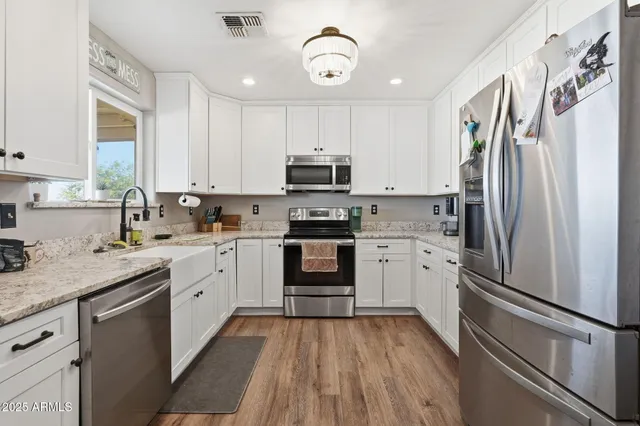 a kitchen with granite countertop a refrigerator stove and sink