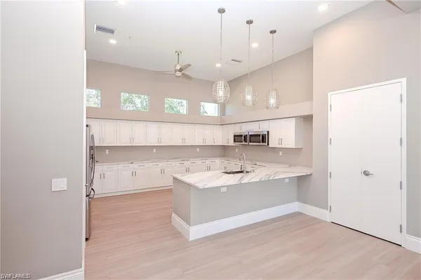 a large white kitchen with a sink a refrigerator and a stove