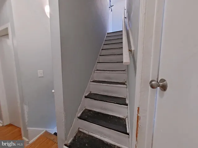 a view of bedroom with stairs and wooden floor