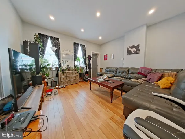 a living room with furniture flat screen tv and wooden floor