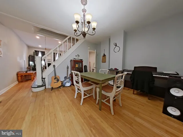 a dining room with wooden floor and chandelier