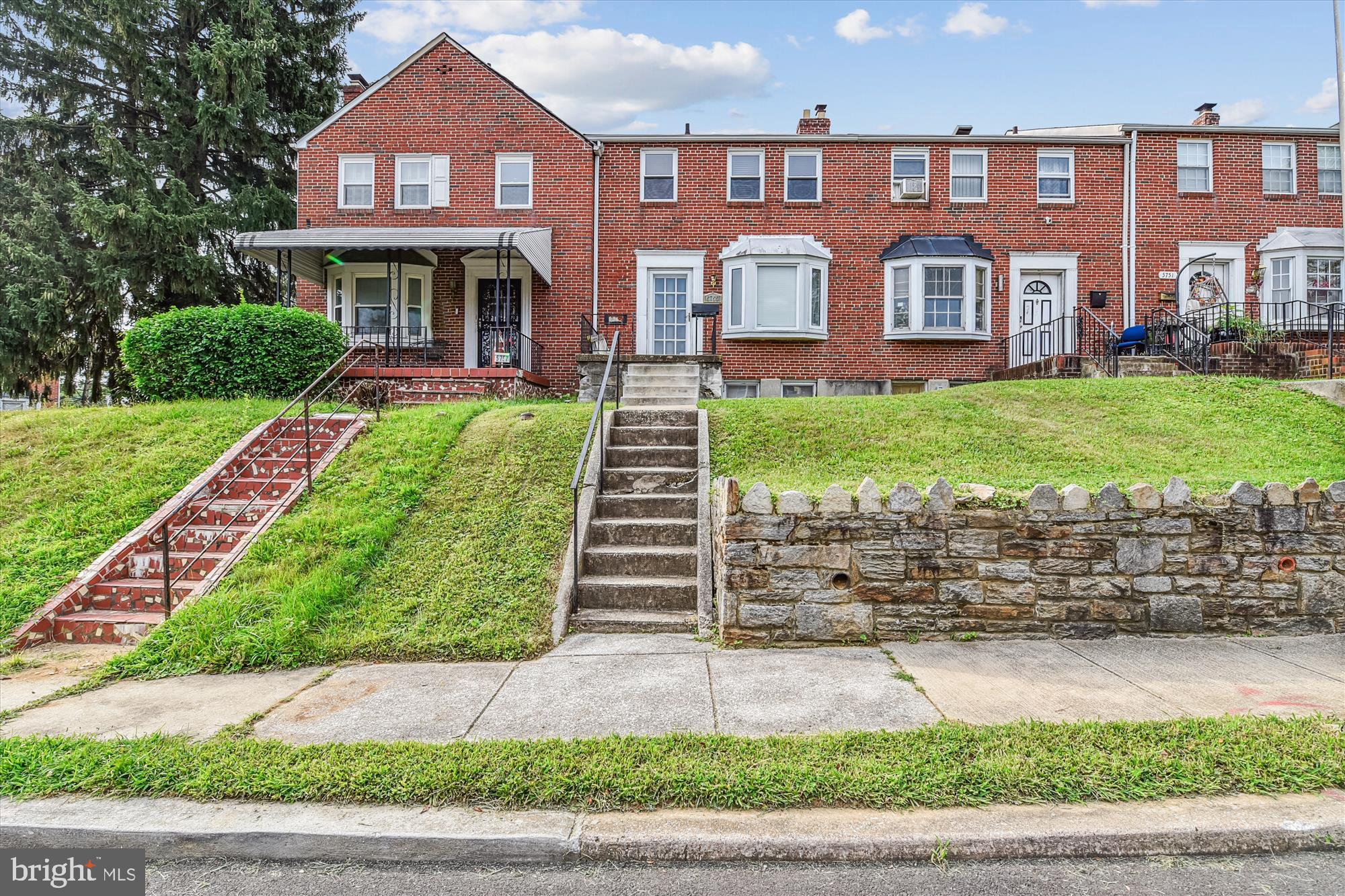a front view of a house with a yard and potted plants