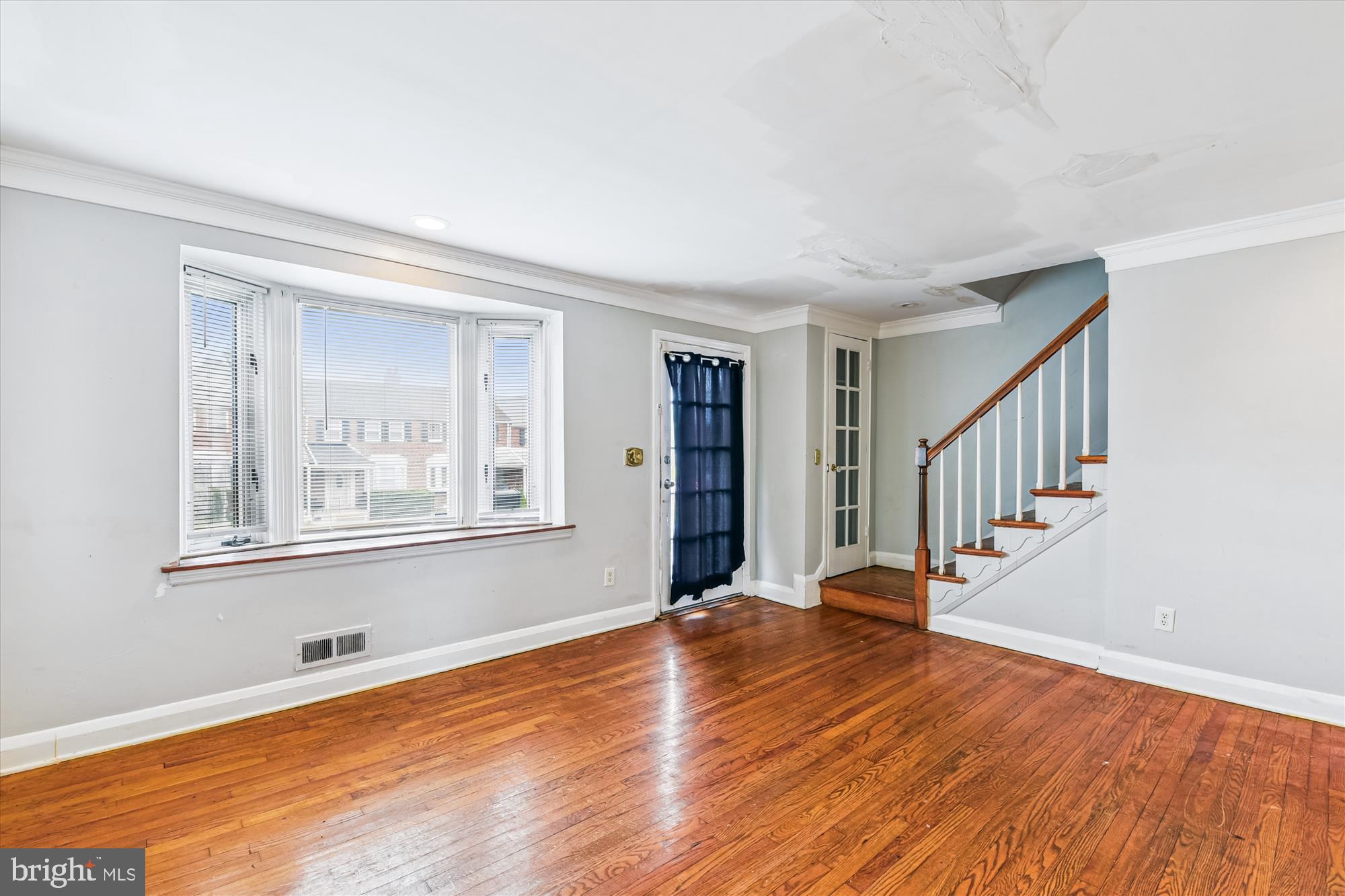 5755 Maplehill Road Baltimore, MD 21239 - Photo 4 of 18 a view of an empty room with wooden floor and a window