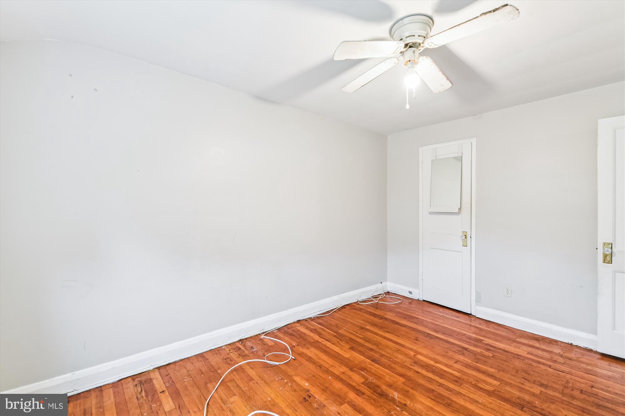 5755 Maplehill Road Baltimore, MD 21239 - Photo 10 of 18 an empty room with wooden floor fan and windows