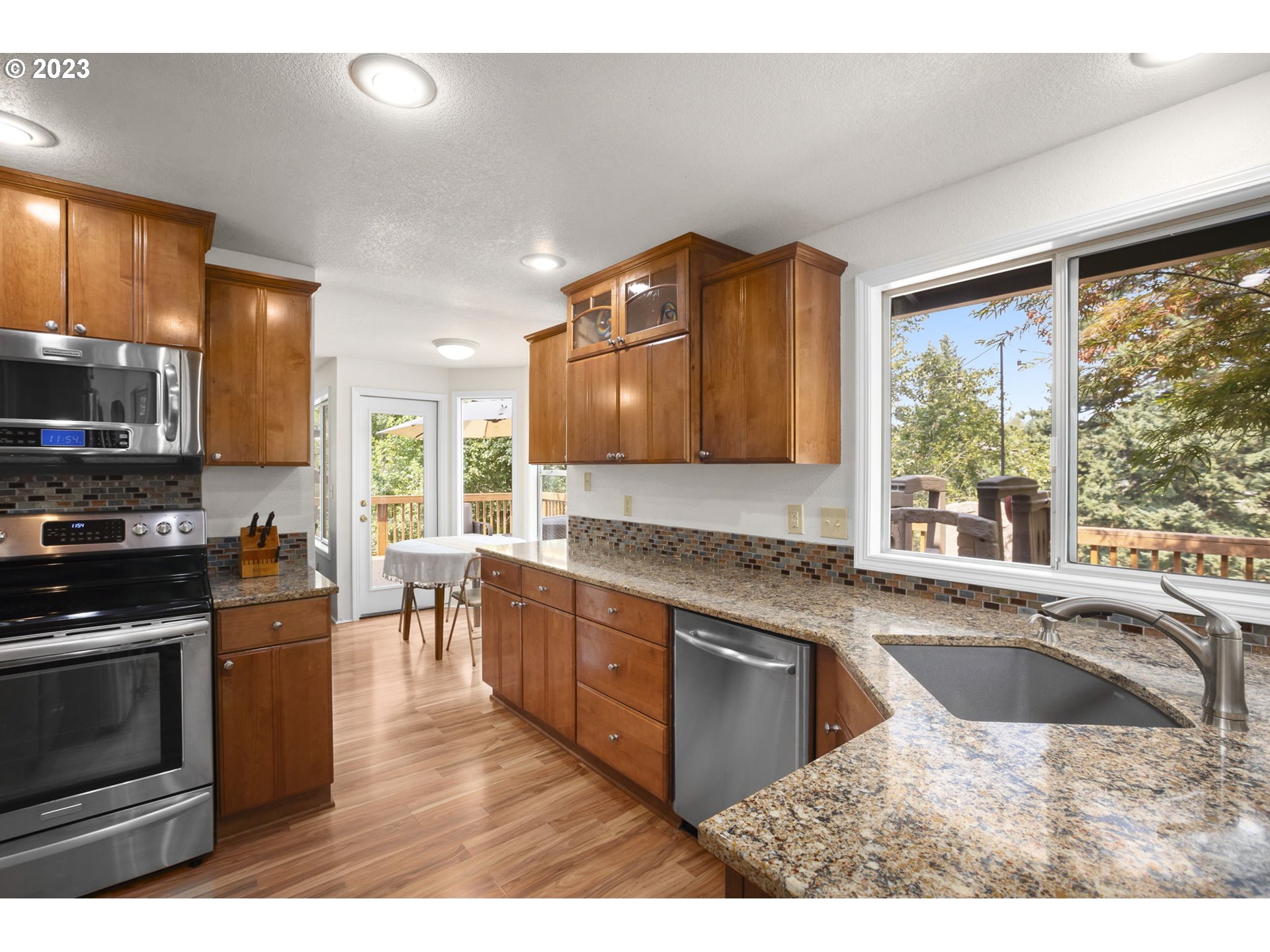 803 Southwest 4th Street Gresham, OR 97080 - Photo 9 of 42 a kitchen with stainless steel appliances granite countertop a stove a sink and a microwave
