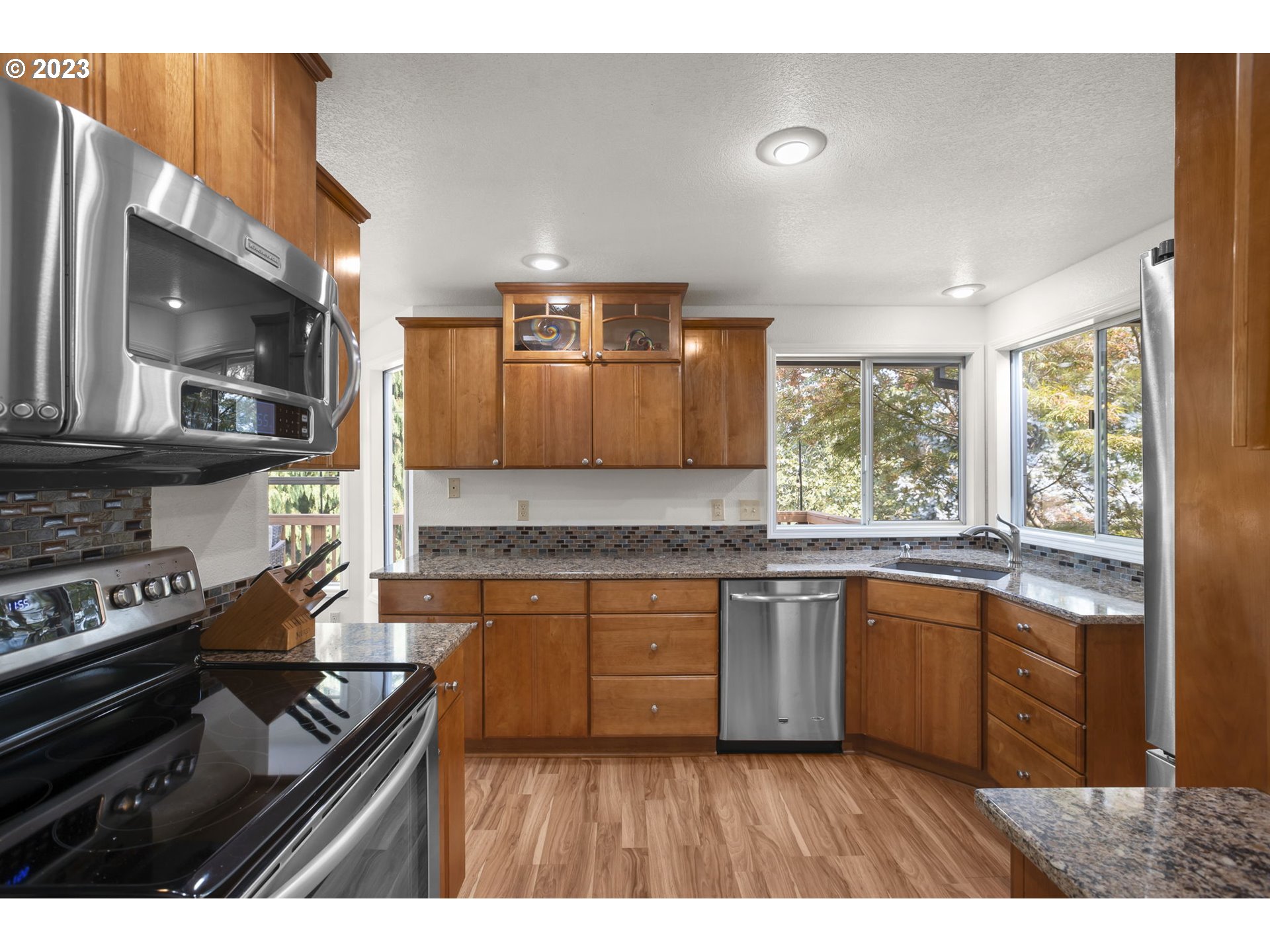 803 Southwest 4th Street Gresham, OR 97080 - Photo 10 of 42 a kitchen with stainless steel appliances granite countertop a stove a sink and a microwave