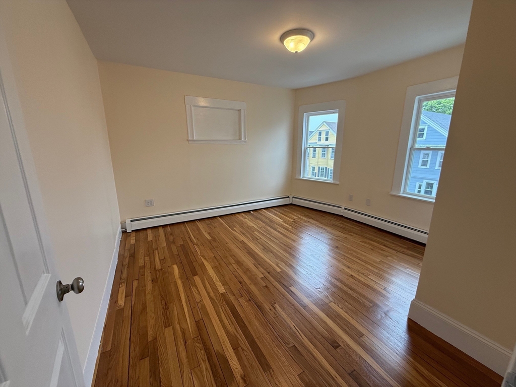 11 Dalrymple Street, Unit 3 Boston, MA 02130 - Photo 5 of 13 wooden floor in an empty room with a window