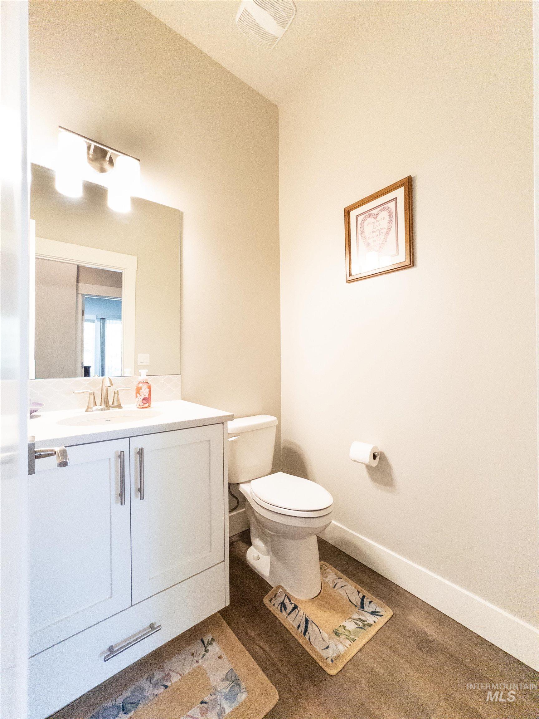 4577 North Comiso Place Meridian, ID 83646 - Photo 20 of 47 Half bathroom with dark wood-type flooring and vanity