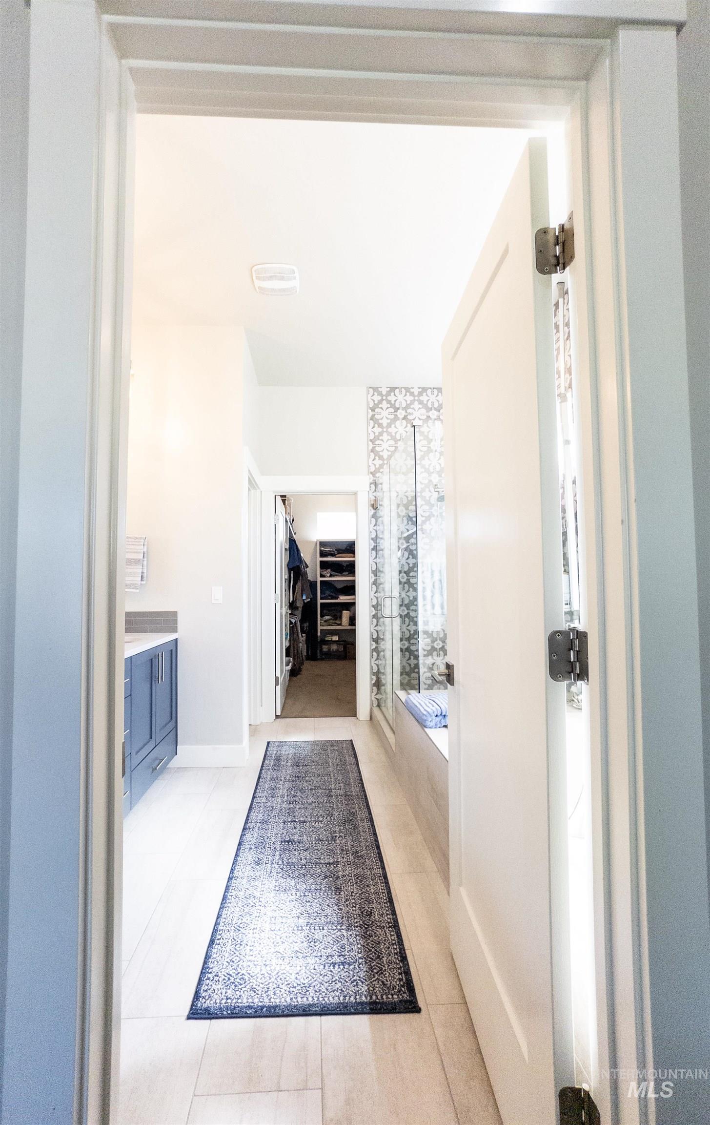 4577 North Comiso Place Meridian, ID 83646 - Photo 24 of 47 Bathroom with vanity, a spacious closet, a shower stall, light tile patterned flooring, and a bath