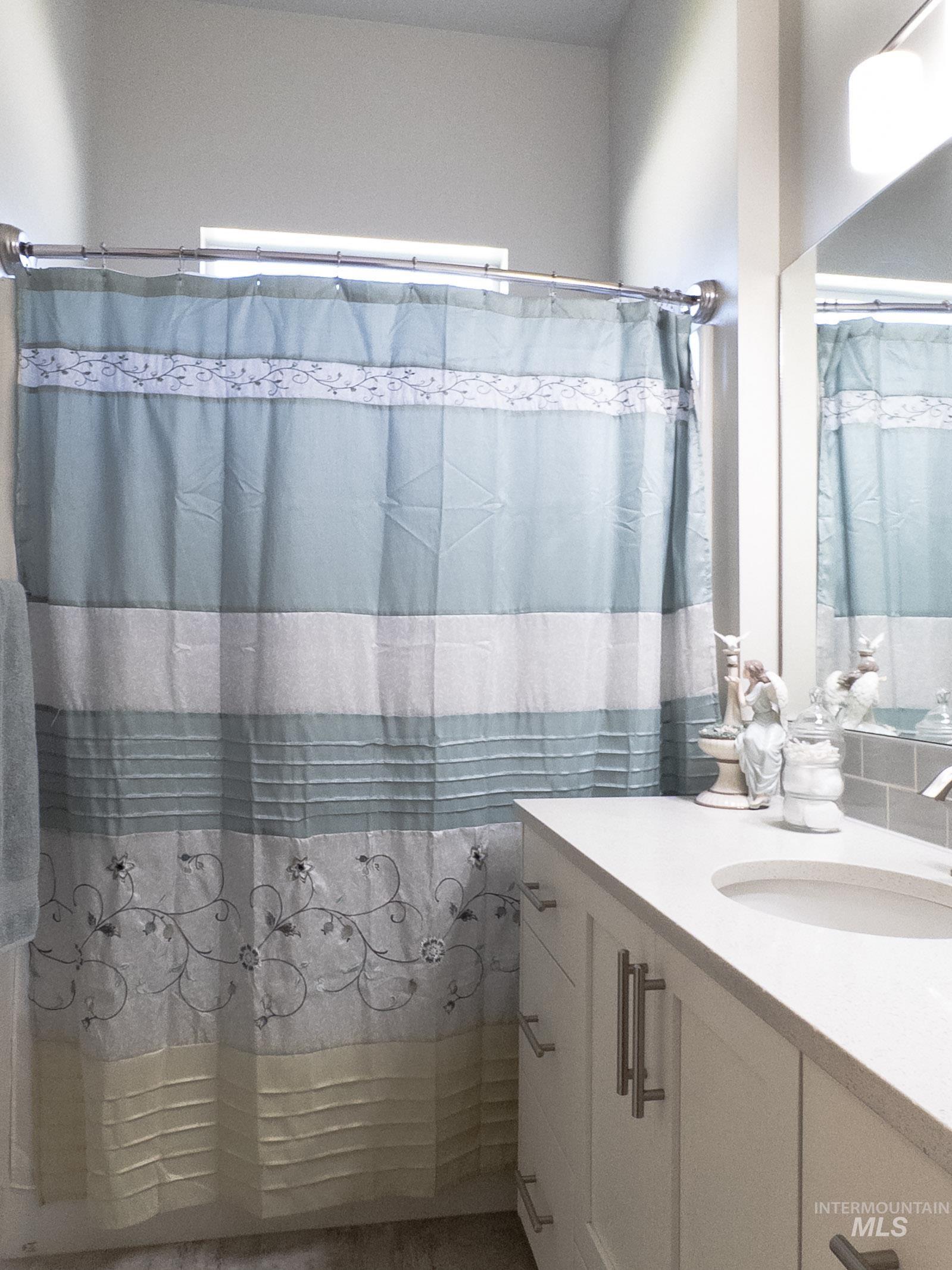 4577 North Comiso Place Meridian, ID 83646 - Photo 33 of 47 Bathroom with vanity and shower / bath combination with curtain
