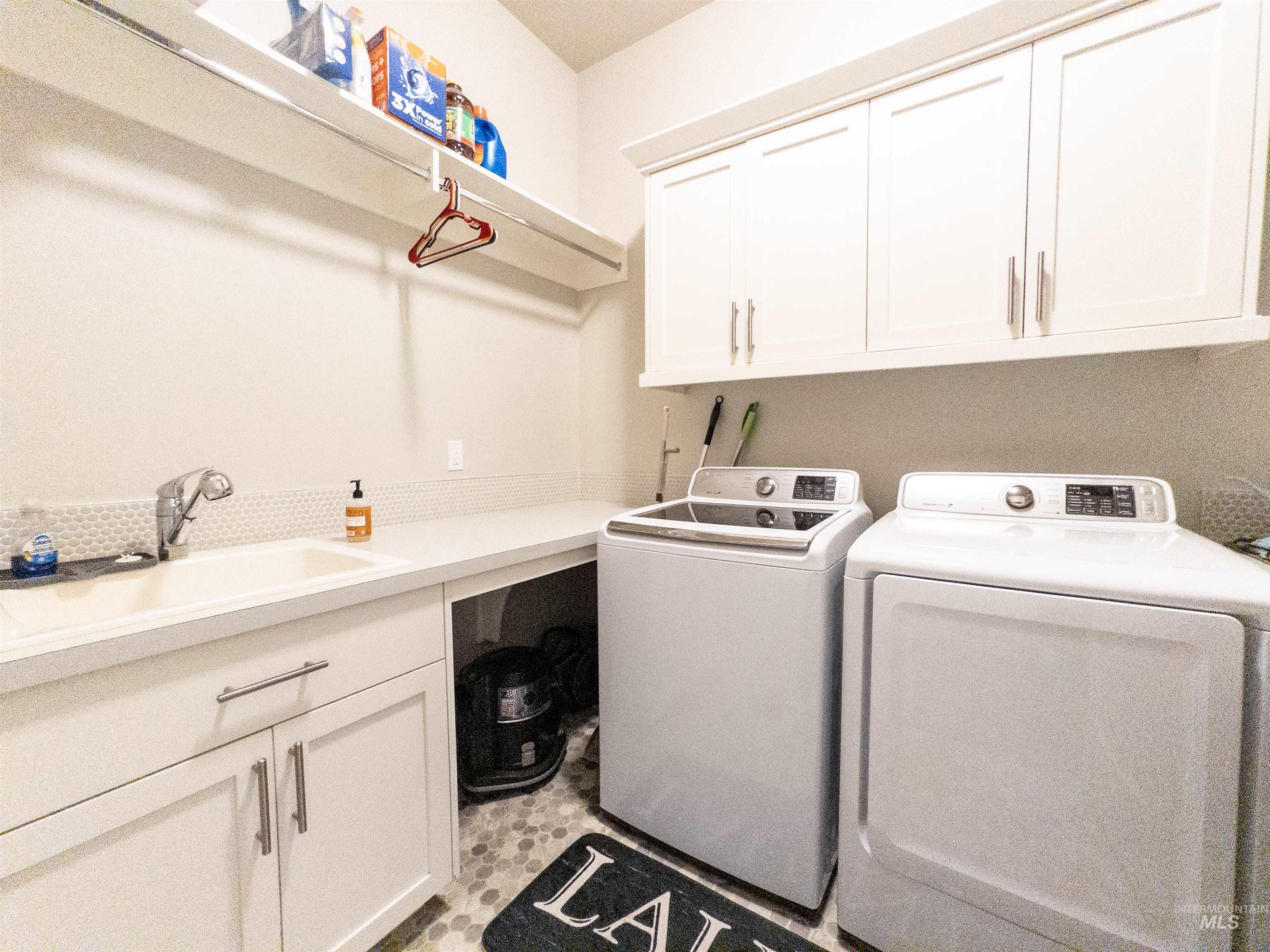 4577 North Comiso Place Meridian, ID 83646 - Photo 36 of 47 Laundry area featuring cabinet space and washer and clothes dryer
