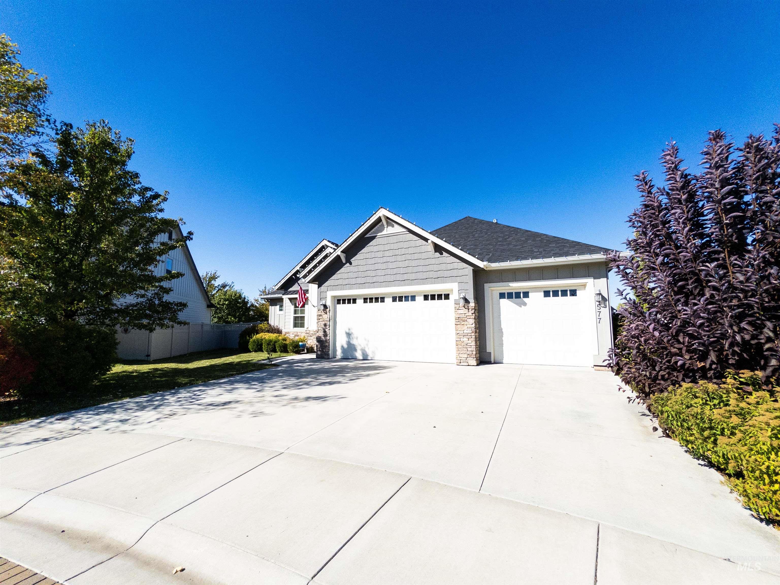 4577 North Comiso Place Meridian, ID 83646 - Photo 46 of 47 Craftsman-style house with stone siding, a garage, and concrete driveway