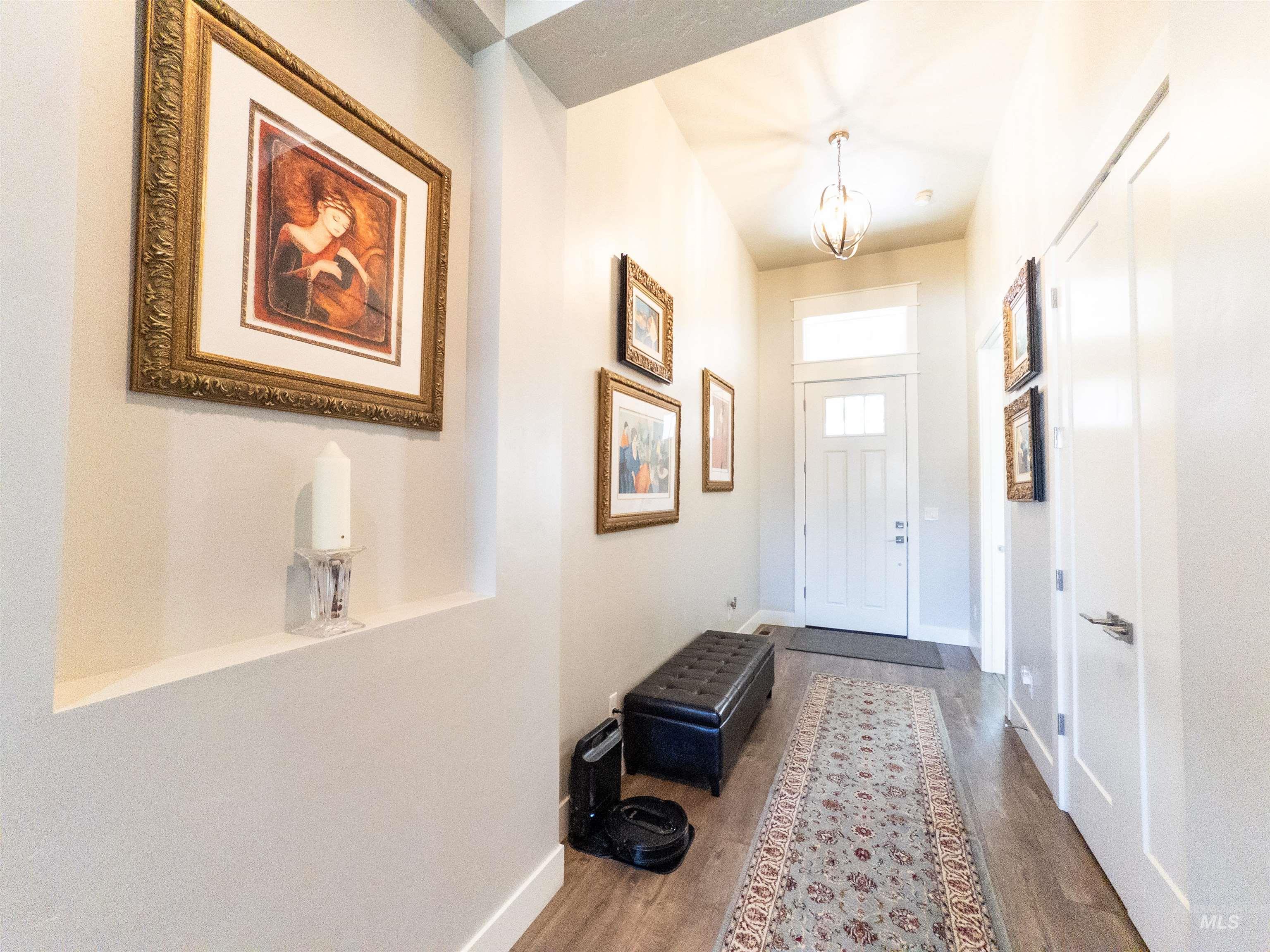 4577 North Comiso Place Meridian, ID 83646 - Photo 5 of 47 Entryway featuring wood finished floors and a chandelier