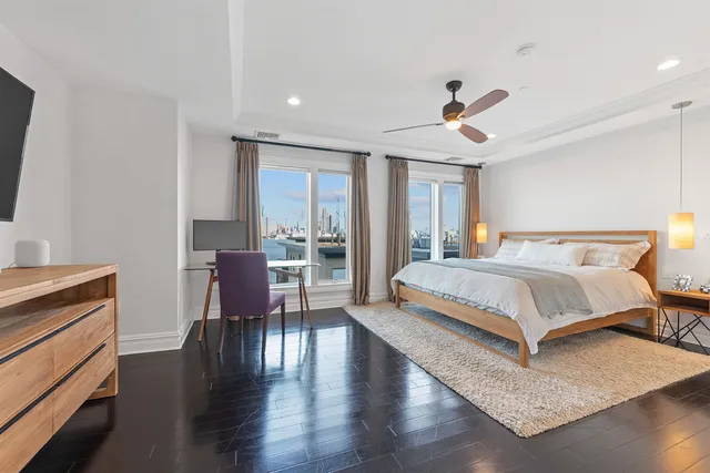 a spacious bedroom with a bed and wooden floor