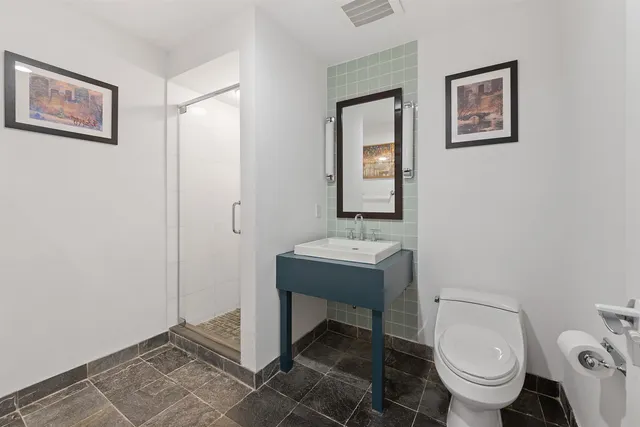 a bathroom with a toilet a sink and mirror