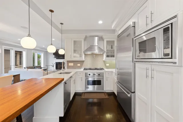 a large kitchen with stainless steel appliances granite countertop a stove a sink and a refrigerator