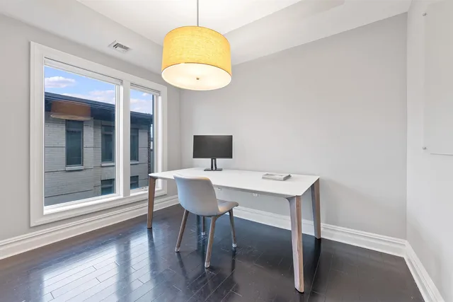 a view of a dining room with a table and chairs