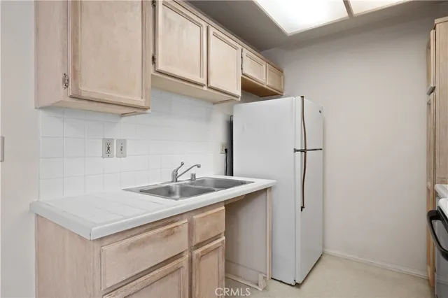 a kitchen with stainless steel appliances granite countertop a sink and a refrigerator