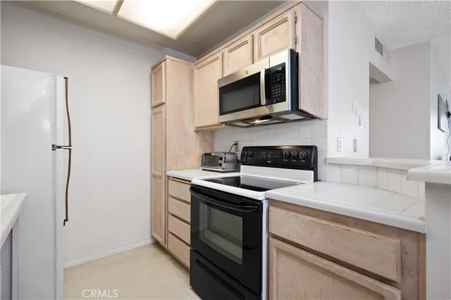 a kitchen with stainless steel appliances white cabinets and a fireplace
