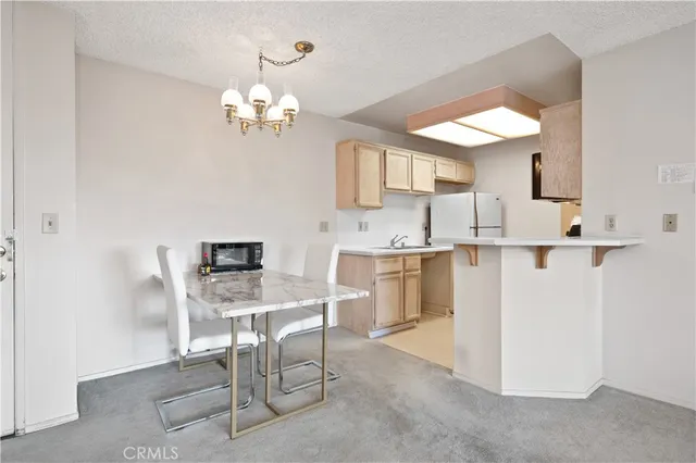 a kitchen with a table chairs and chandelier