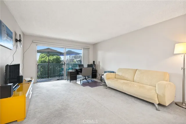 a living room with furniture a flat screen tv and a large window
