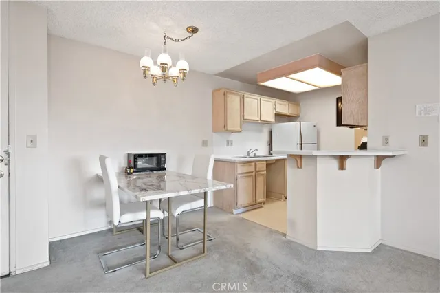a kitchen with a table chairs and chandelier