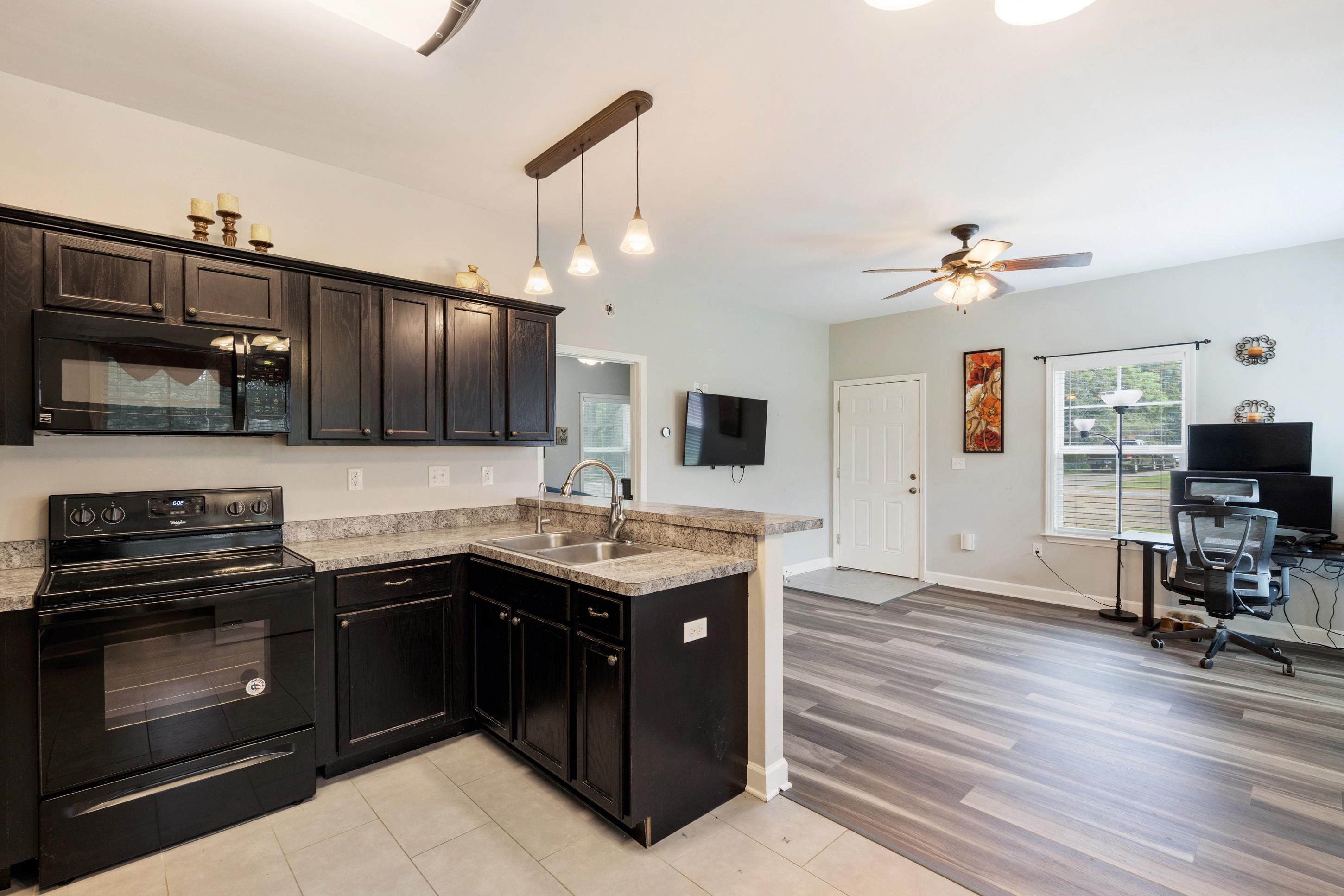 7757 Brunswick Road Millington, TN 38053 - Photo 27 of 40 Modern kitchen featuring black cabinetry, light-toned countertops, and a full suite of black appliances