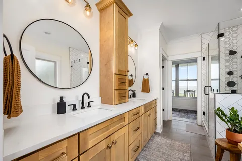 a bathroom with a double vanity sink mirror and shower