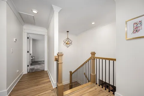 a view of a hallway with wooden floor and staircase