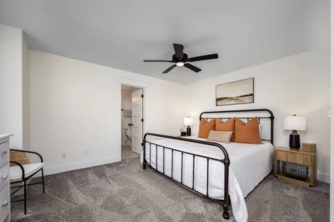 a bedroom with a large bed and a chandelier