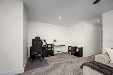 a view of a workspace with furniture and a ceiling fan
