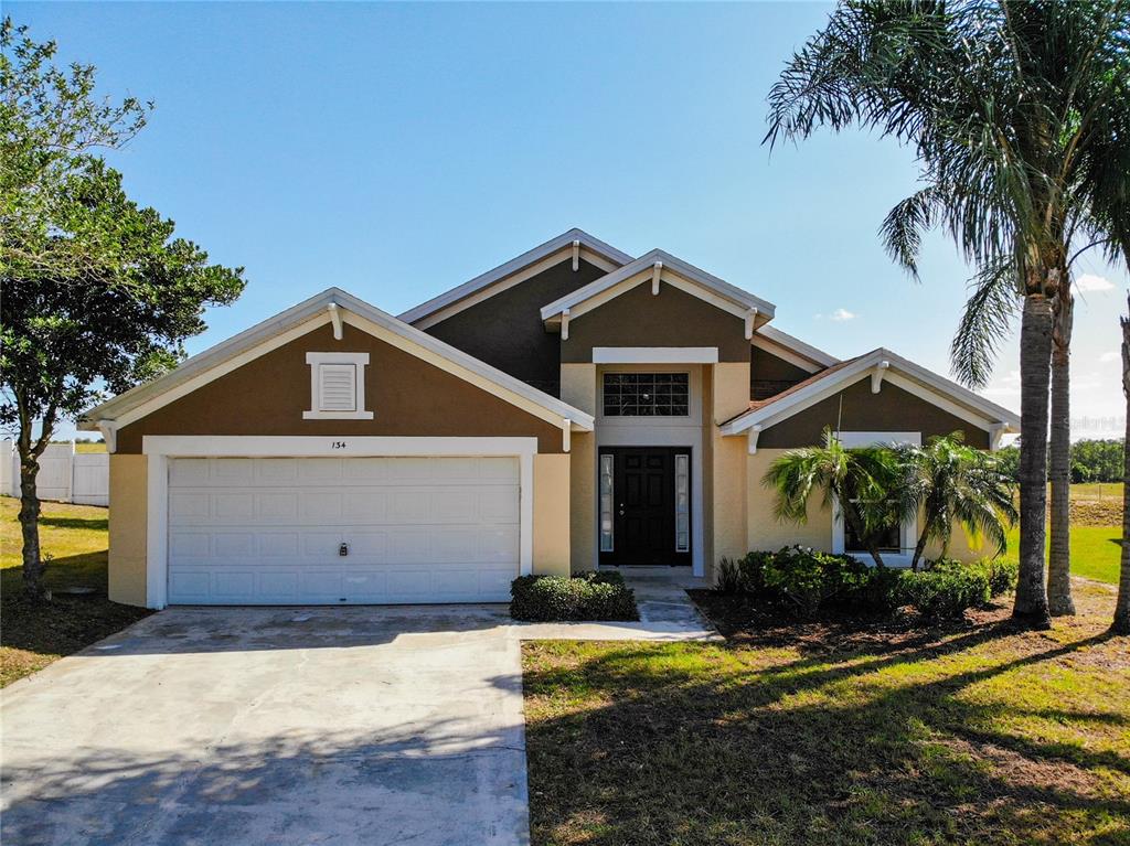 134 Argyle Gate Loop Road Dundee, FL 33838 - Photo 1 of 1 a front view of a house with a yard garage and outdoor seating