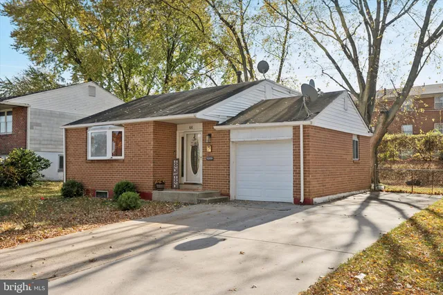 a front view of a house with a yard and trees